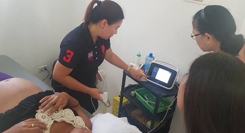 A woman taking a pregnant woman’s ultrasound